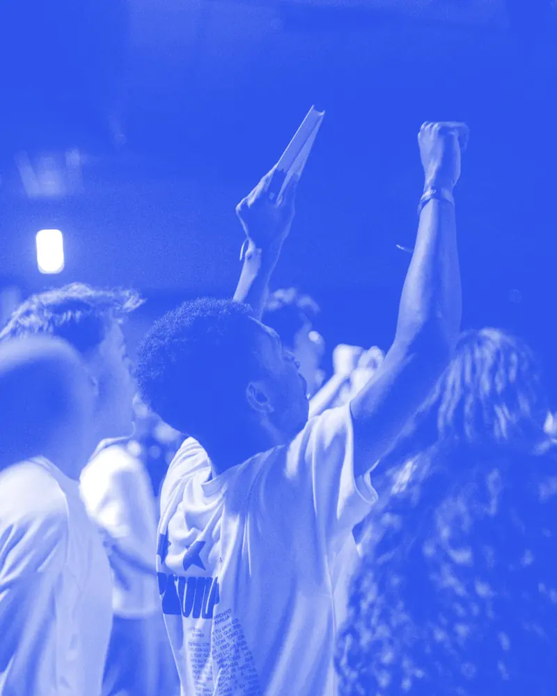 Igreja em adoração, com as mãos levantadas, na Conferência ONE 2025